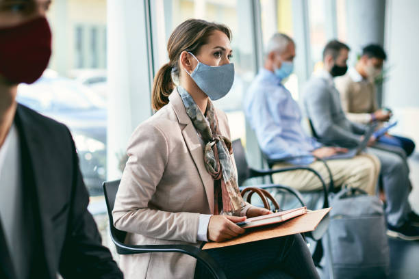 istock Female candidate with face mask waiting for an appointment for a job interview. 1322088843