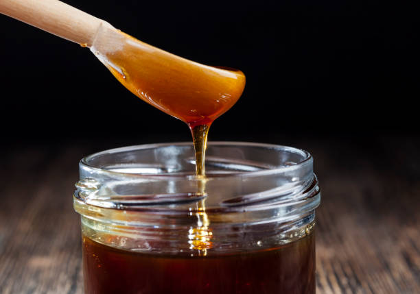 istock sweet honey flowing into jar 1322091906