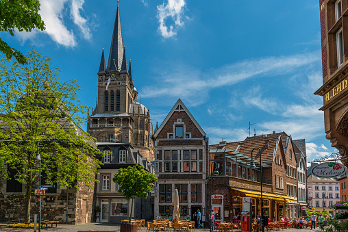 Aachen, Germany - May 20, 2012: Historic city centre of very old town Aachen in Germany. Lot of pubs with many people in very narrow alleys. Most of buildings have brickwalls  and most streets have cobblestones.