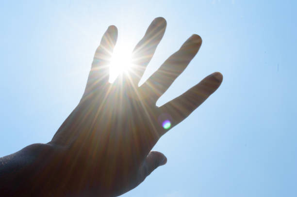 istock Hand reaching sun light. Sunlight rays coming through human hand. Praying praising religious blessing background. Hope motivation, ethereal, aspirations, spirituality and freedom concept. 1322096619