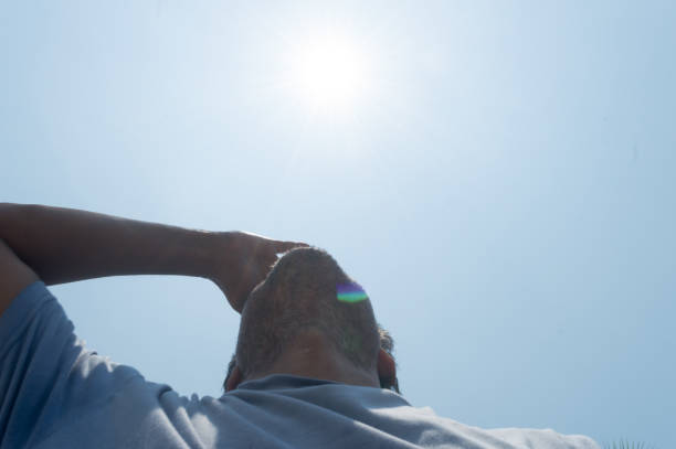 istock Scorching Hot summer sunlight rays pouring on human head. Hand covering sun light heat temperature. Protection from ultraviolet light and sunburn background.  Sunstroke, heatstroke, greenhouse effect. 1322096800
