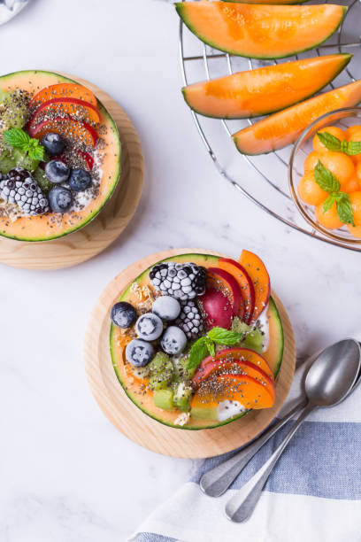 Fruit salad with yogurt in carved melon cantaloupe bowl