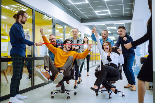 istock Young colleagues group having fun together, riding on chairs in office, diverse excited office workers enjoying break, laughing, engaged funny activity, celebrating corporate success. 1322099963