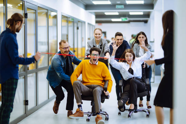 istock Young colleagues group having fun together, riding on chairs in office, diverse excited office workers enjoying break, laughing, engaged funny activity, celebrating corporate success. 1322100092
