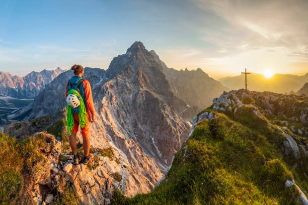 mountain climber at summit cross with glory view to watzmann east wall, nationalpark berchtesgaden - passion mountain range mountain national park imagens e fotografias de stock