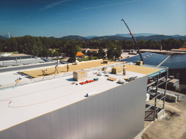 istock Construction workers working on the roof of a warehouse 1322103405