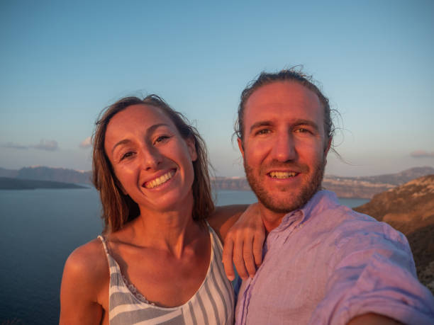 istock Tourists take selfie on coastline at sunset 1322103408