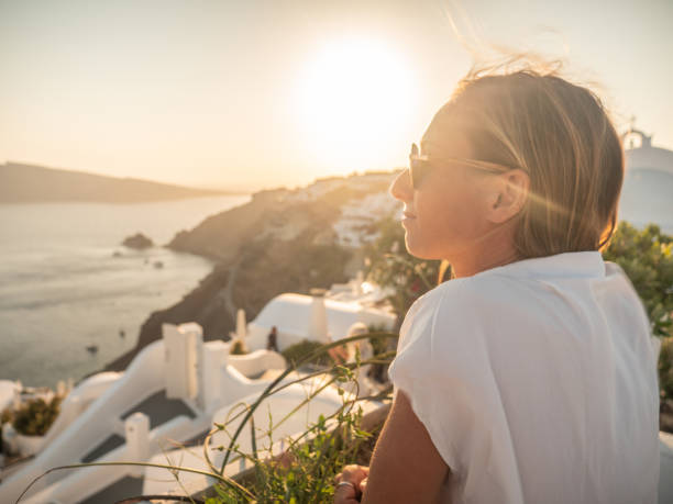 istock Woman contemplates Santorini from top, Greece 1322103578