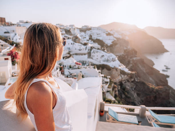 istock Woman contemplates Santorini from top, Greece 1322103638