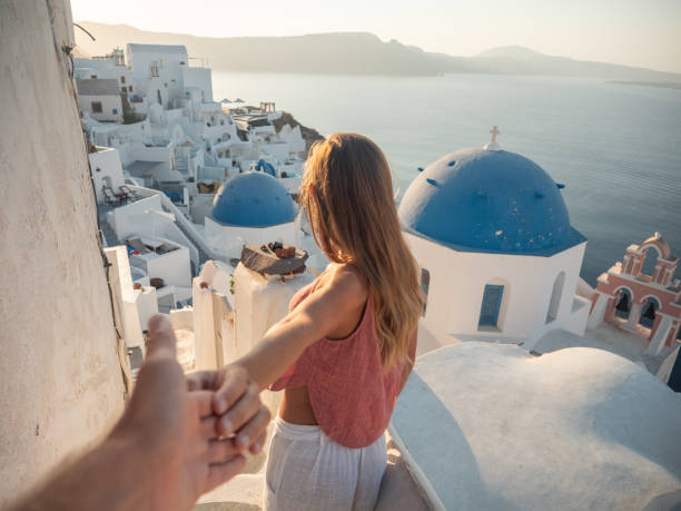 Couple holding hands in Santorini, follow me to Greece stock photo