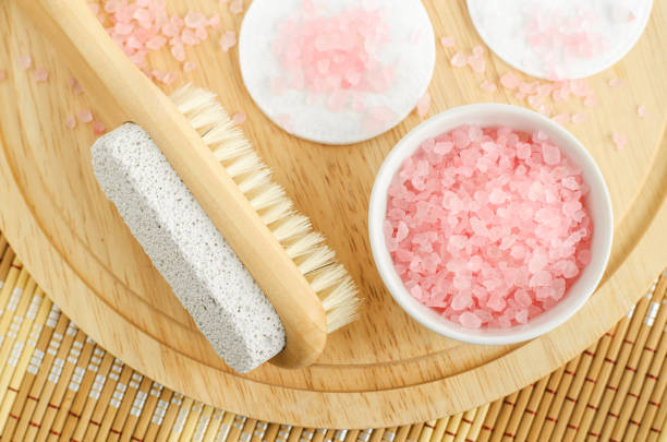 Small white bowl with pink Himalayan crystal bath salt (foot soak) and wooden brush with pumice stone. Homemade pedicure, spa and beauty treatment recipe. Small white bowl with pink Himalayan crystal bath salt (foot soak) and wooden brush with pumice stone. Homemade pedicure, spa and beauty treatment recipe. bath salt stock pictures, royalty-free photos & images