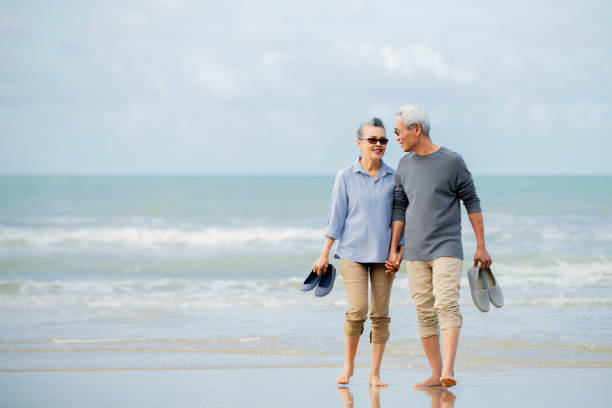 istock asian senior couple walking  on beach 1322107919