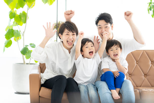 istock parents and children watching TV with their hands raised 1322112158