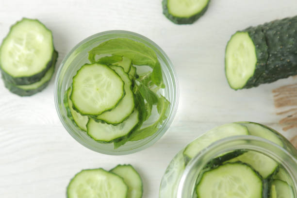 istock water with cucumber. Refreshing diet water with cucumber in a glass cup on a light background. detox drink concept. summer refreshing drink. top view 1322113151