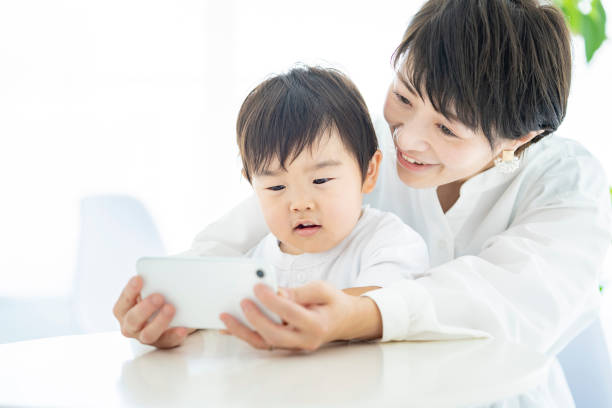 istock Child and mom watching smartphone screen 1322113679