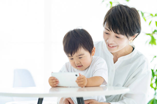istock Child and mom watching smartphone screen 1322113777