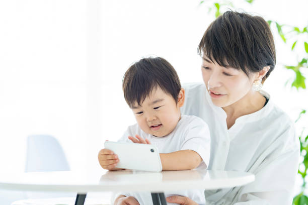 istock Child and mom watching smartphone screen 1322113978