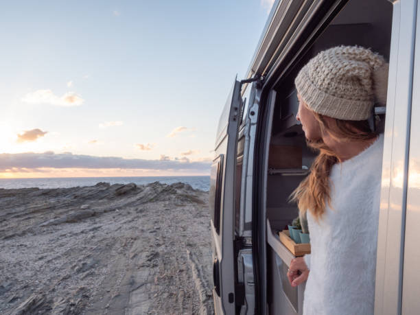 istock Woman looks at coastline from her van 1322115371