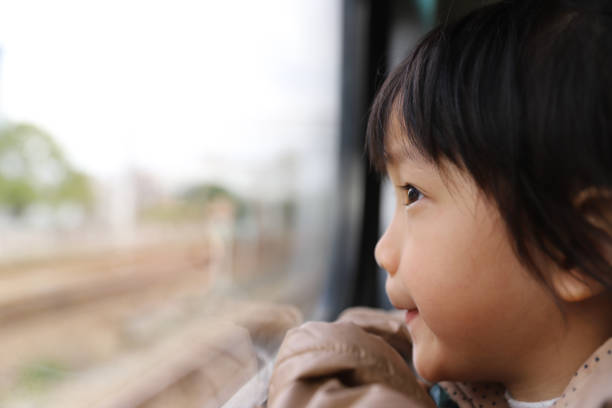 istock a asian girl not wearing mask  by train. 1322115413