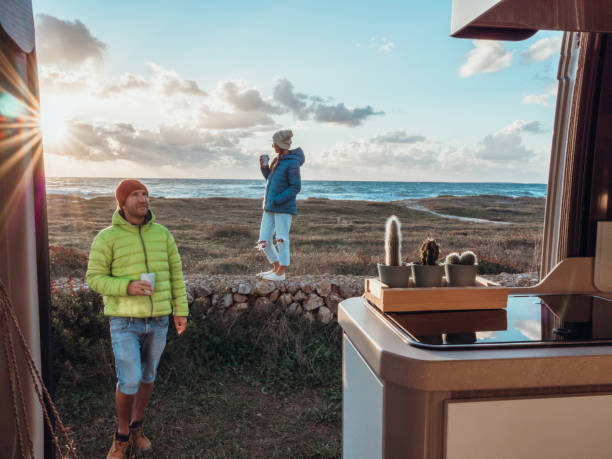 istock Couple relaxing outside their camper van at sunset 1322115468