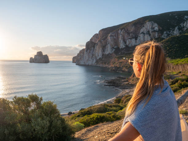 Woman contemplates beautiful sunset, Sardinia