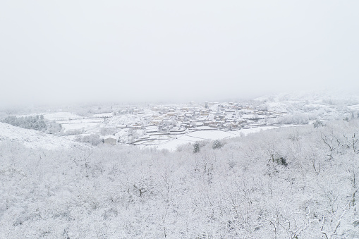Drone aerial view of a road and remote village covered with snow in the North of Portugal, Vila Real