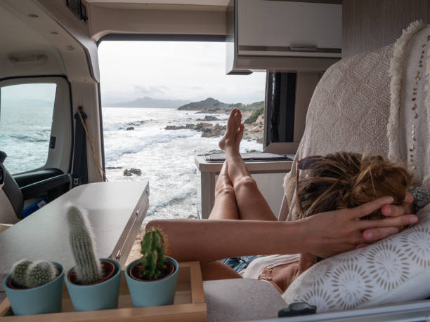istock Woman lying in her van looking at ocean 1322116362
