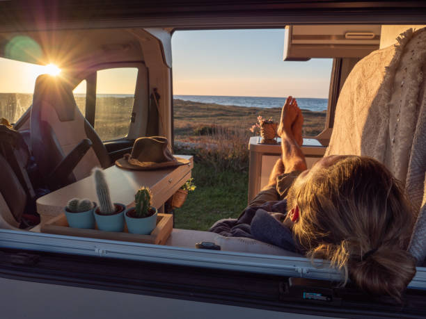 istock Man lying in a van looking at ocean 1322116455