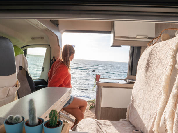 istock Woman in her van looking at ocean 1322116523