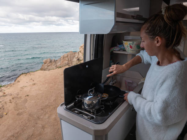 istock Woman cooking in her van, ocean view 1322116539