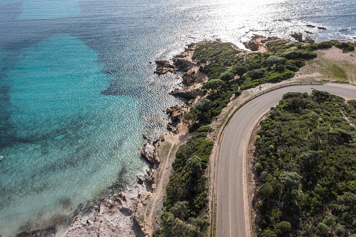 View of blue clear beach and coastal road in Sardinia, Italy