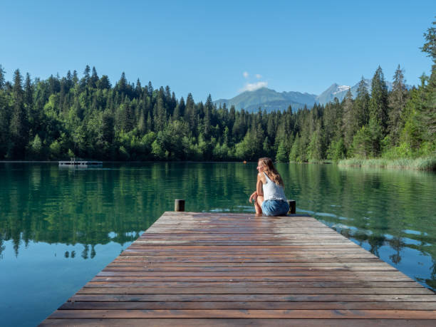istock Woman contemplating mountain lake 1322117023