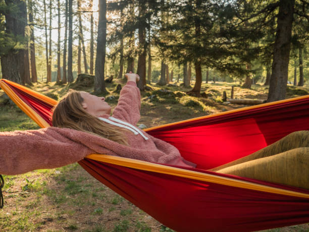 istock Barefoot woman relaxes in hammock in the forest 1322117936