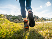 Woman hikes up on mountain trail, low angle view