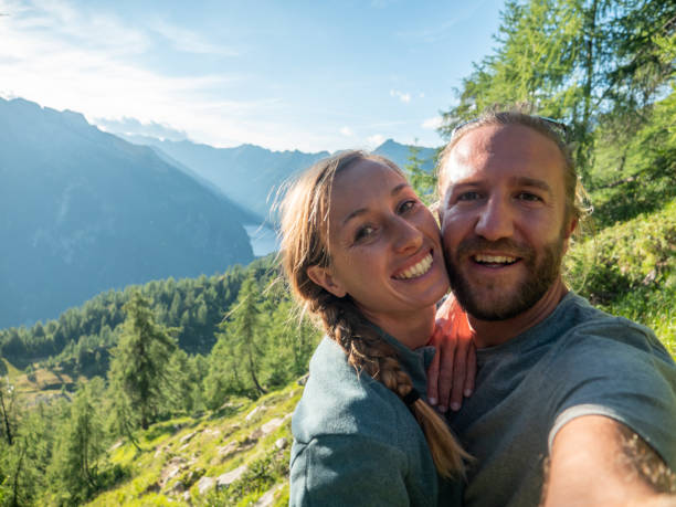 istock Couple take selfie in alpine landscape, Summer 1322118315