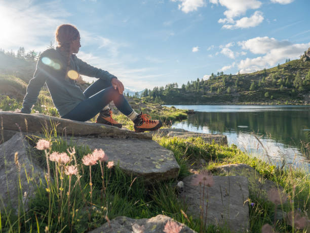 女性は日の出時に湖を熟考する - switzerland european alps ticino canton scenics ストックフォトと画像