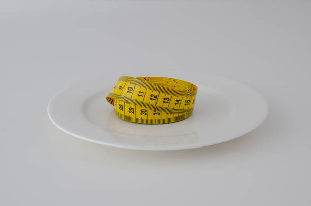 White plate with tape measure on clean background