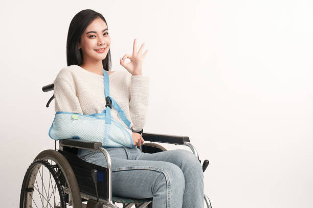 braço quebrado linda jovem asiática com mulher feliz sorrindo em uma cadeira de rodas em fundo branco, conceito de saúde, acidente, seguro, seguro de vida, bem-estar, hospital. - physical injury hospital cast doctor - fotografias e filmes do acervo