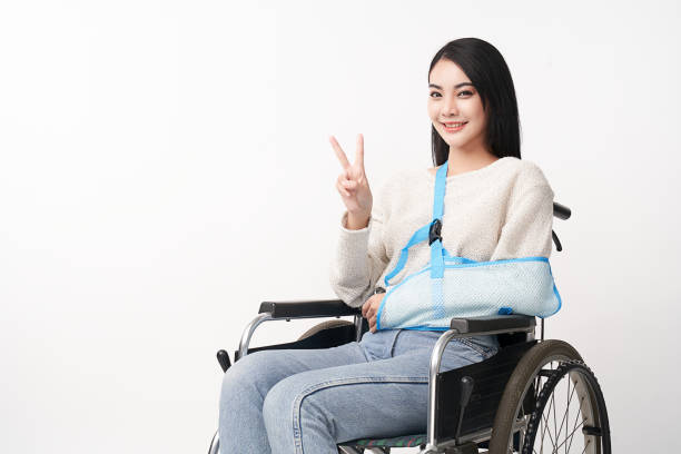 braço quebrado linda jovem asiática com mulher feliz sorrindo em uma cadeira de rodas em fundo branco, conceito de saúde, acidente, seguro, seguro de vida, bem-estar, hospital. - physical injury hospital cast doctor - fotografias e filmes do acervo