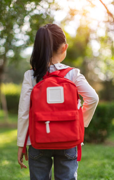 istock Little girl carrying school bag 1322121314