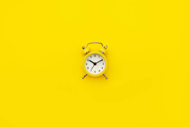 istock Small alarm clock. Monochrome yellow. Minimalistic concept. 1322122042
