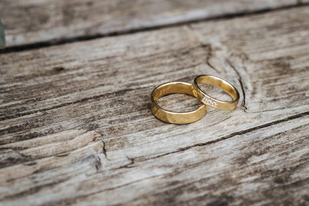 istock Beautiful wedding rings laying on wooden texture 1322130203