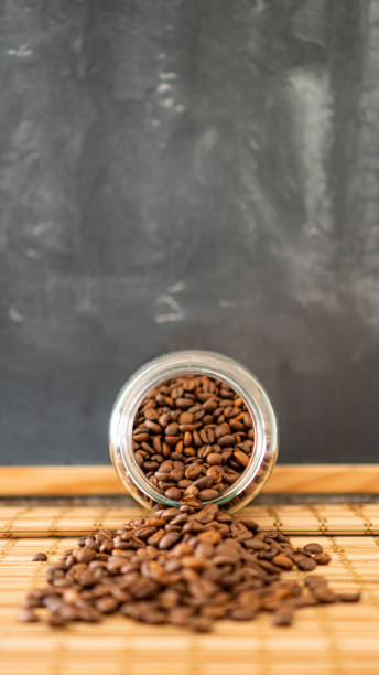 istock Coffee beans spilling from a glass jar 1322131952