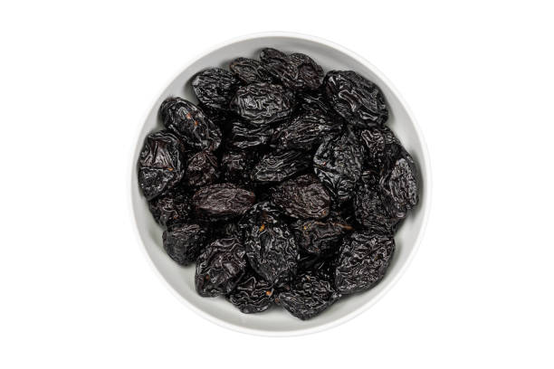 istock Prunes in a bowl on a white background. dry plums 1322132943