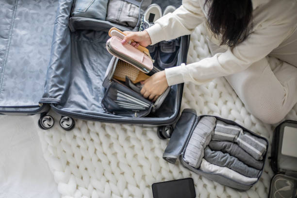 istock Focused woman making list packing suitcase organization. Clothes, cosmetic bag, case for equipment 1322135155