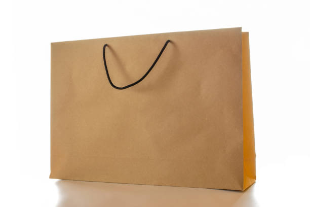 istock Brown paper bag texture. Kraft recycle package with empty blank space for design mockup isolated on white background. Delivery service concept. Copy space. Advertising area. 1322135996