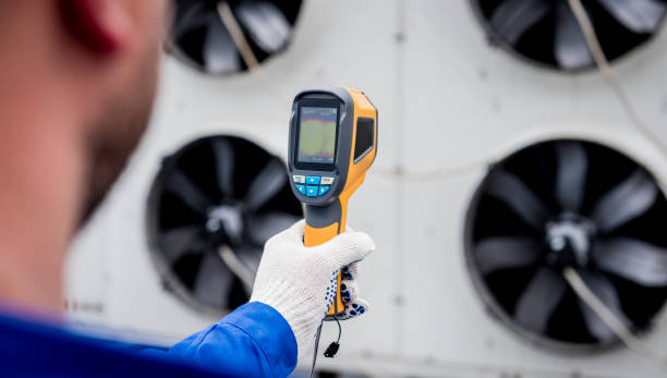 istock Technician uses a thermal imaging infrared thermometer to check the condensing unit heat exchanger. 1322138835