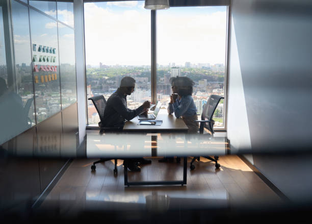 jovem presidente indiano tendo entrevista com gerente afro-americano contratando para o trabalho. - reunião de pessoal - fotografias e filmes do acervo