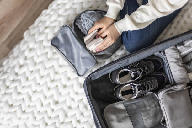 istock Unidentified woman puts lingerie in trip storage container use konmari method packing suitcase 1322139199