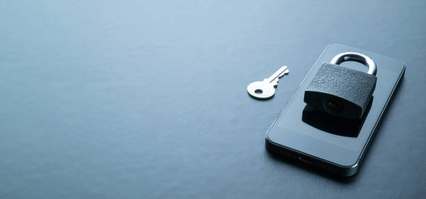 istock Internet protection. Modern space grey mobile phone with padlock, key on dark background. Darkweb, darknet and hacking concept. 1322139223